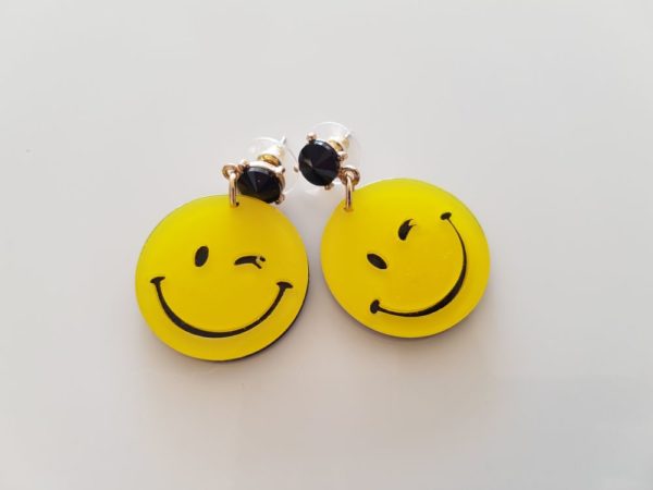Ein Paar gelbe Ohrstecker mit dem berühmten Smiley